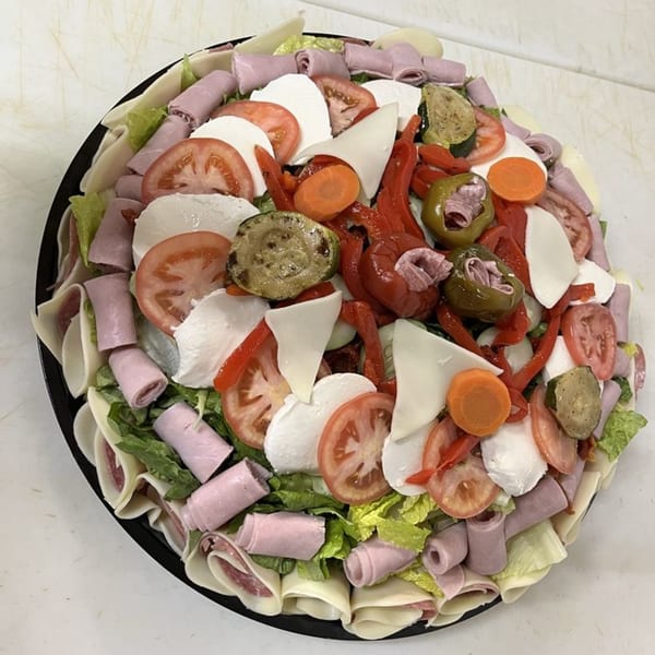 Al's Famous Pizza antipasto platter with rolled meats, cheeses, tomatoes, and grilled vegetables.