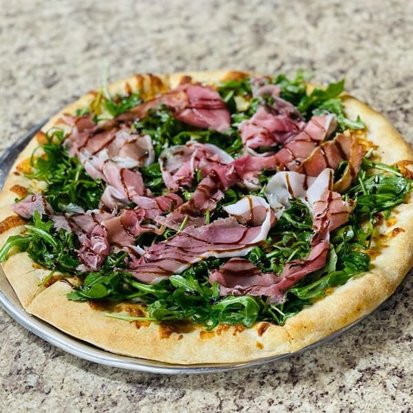 Al's Famous Pizza's Italian pizza topped with prosciutto, fresh arugula, and balsamic glaze.